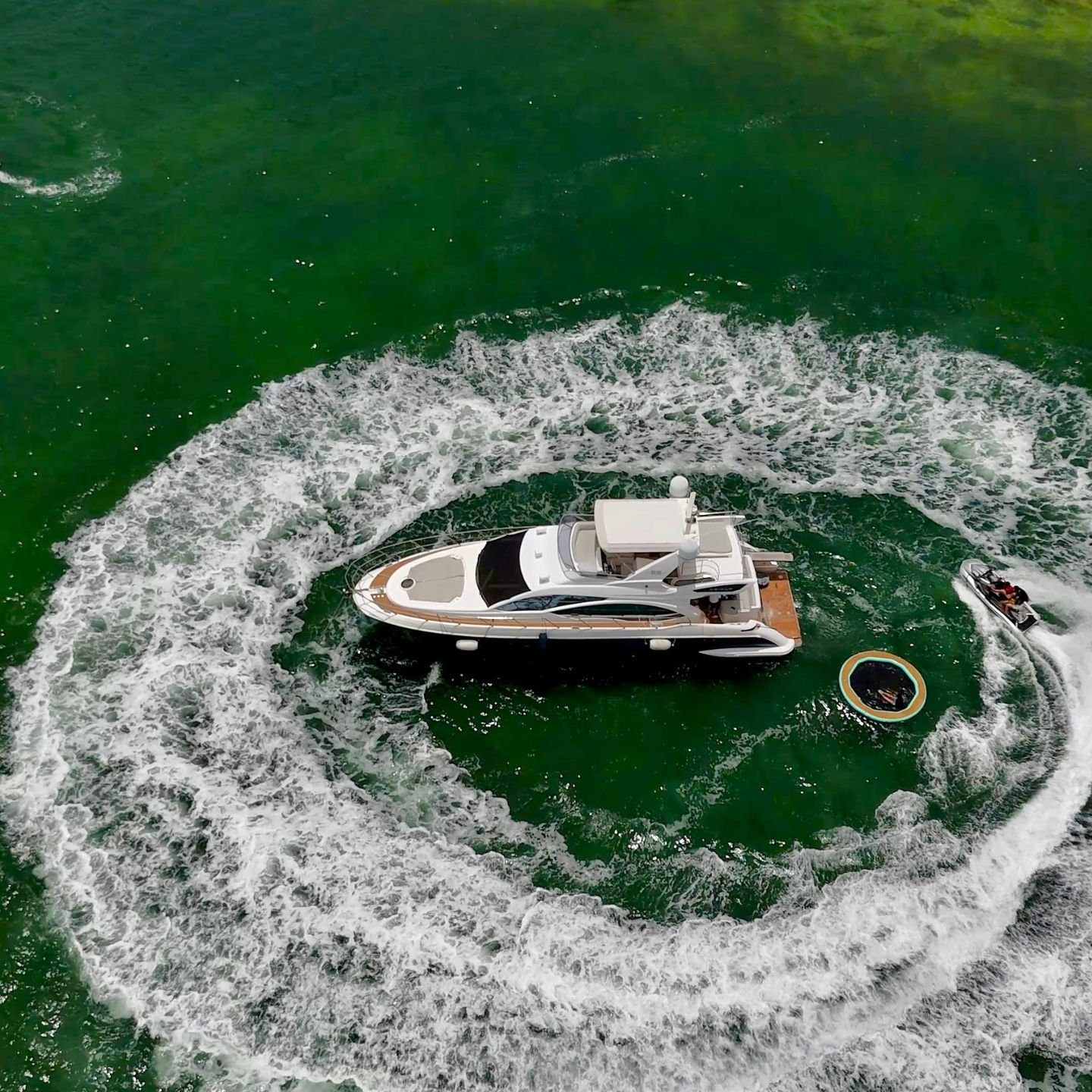 Aerial view of a yacht circling with a float on Biscayne Bay