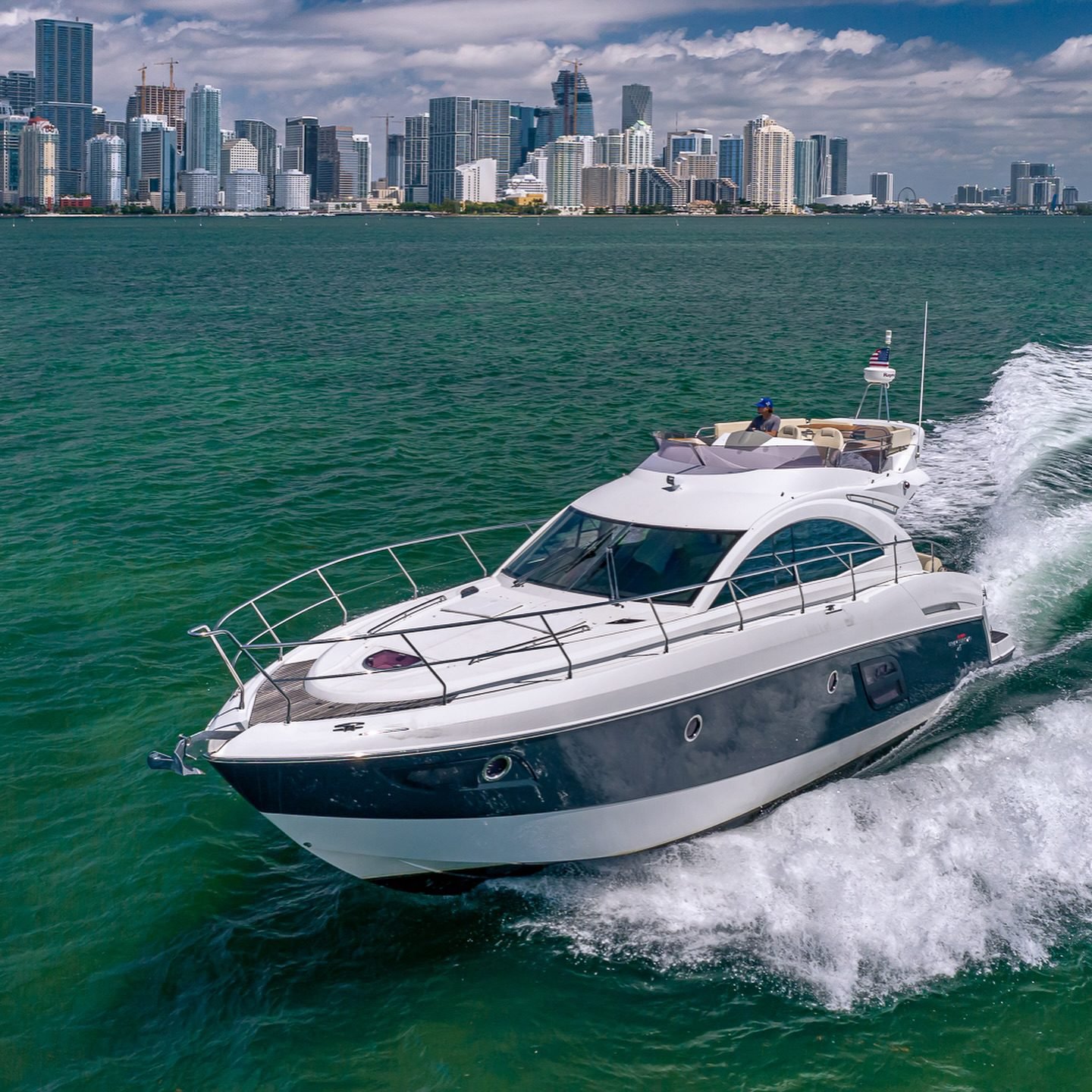 Sport yacht cruising at speed on green water off Miami