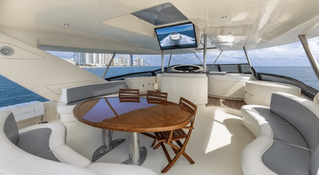 Yacht flybridge lounge with dining table under a hardtop